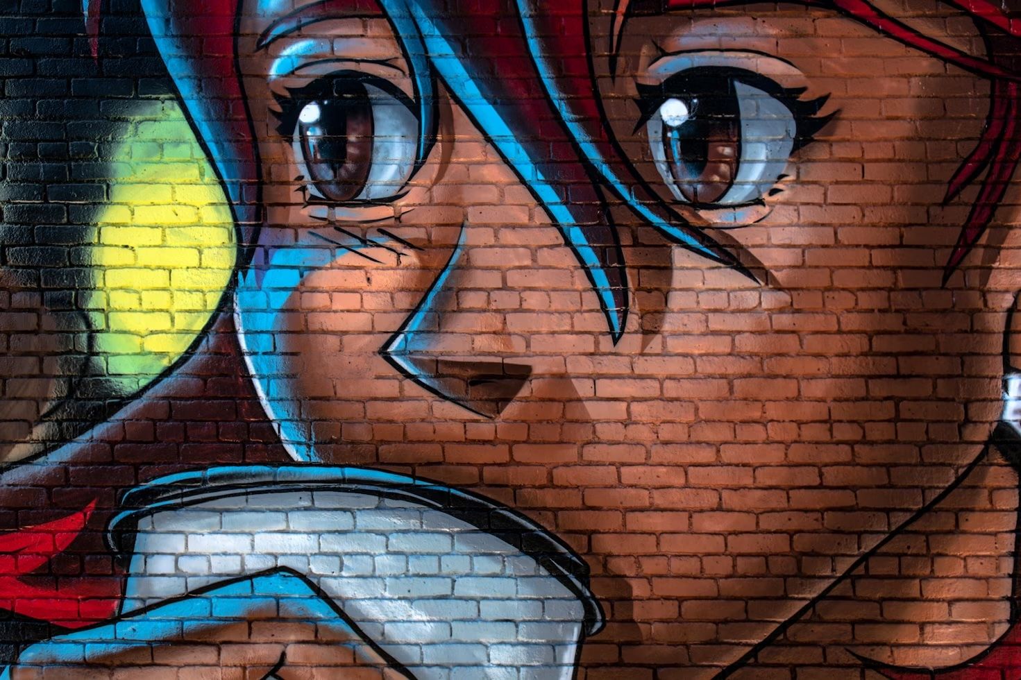 A screenshot of a brick wall with an anime character graffitid onto it