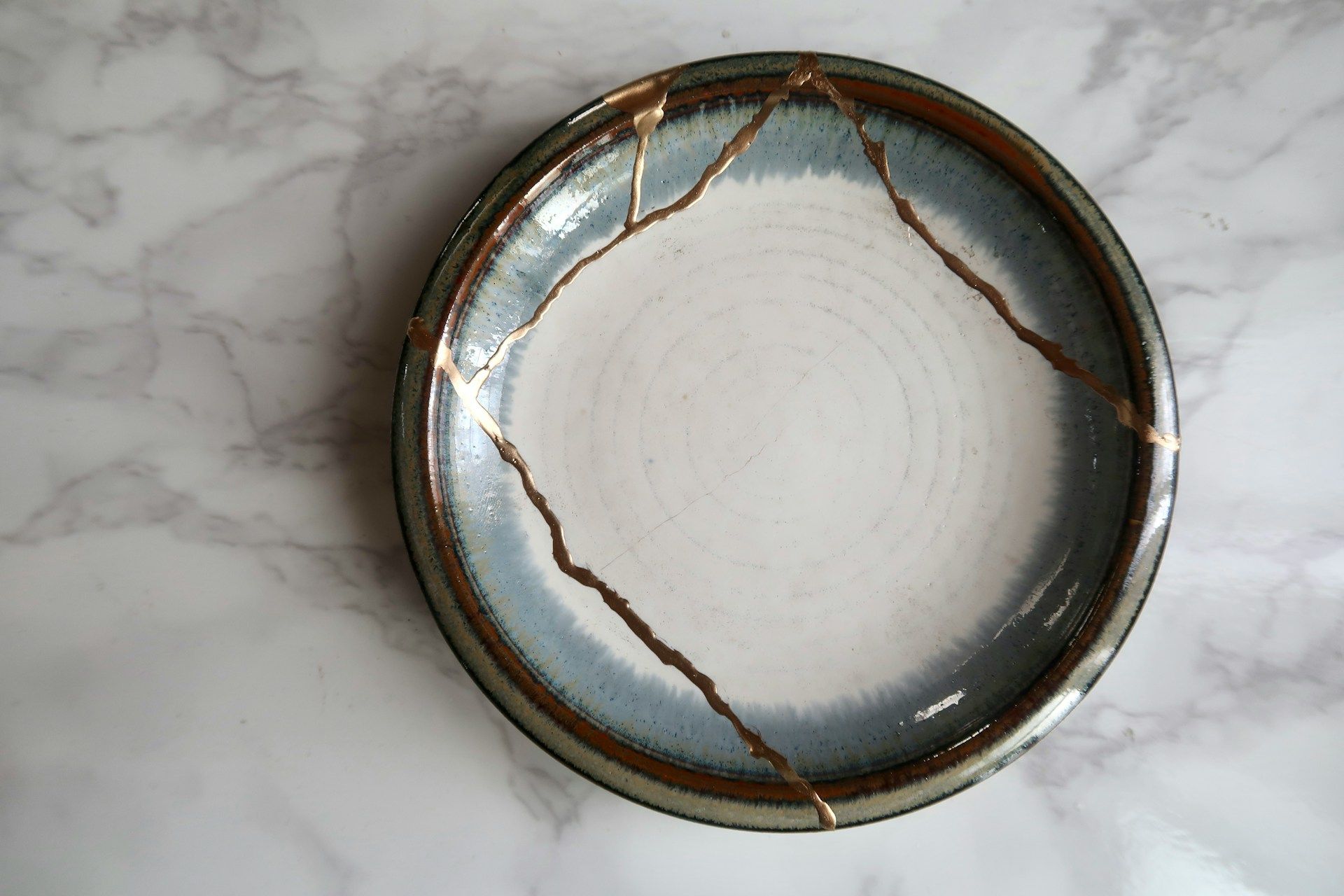 A broken plate that has been repaired with gold lacquer, demonstrating the Japanese kintsugi technique
