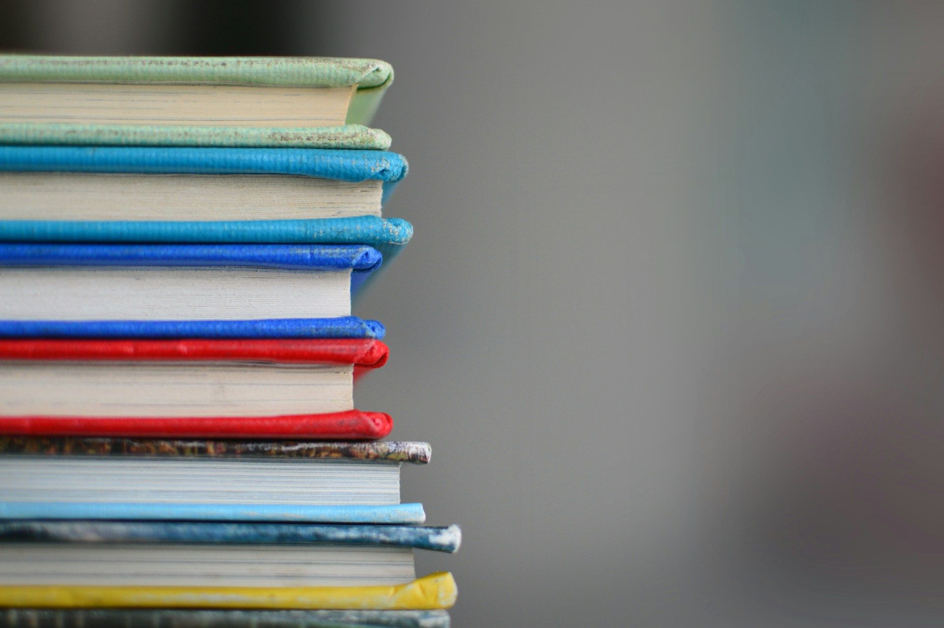 A pile of (likely unread) books on a table, which is very much in the spirit of tsundoku 